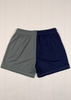 Gray and navy shorts on a white wooden surface