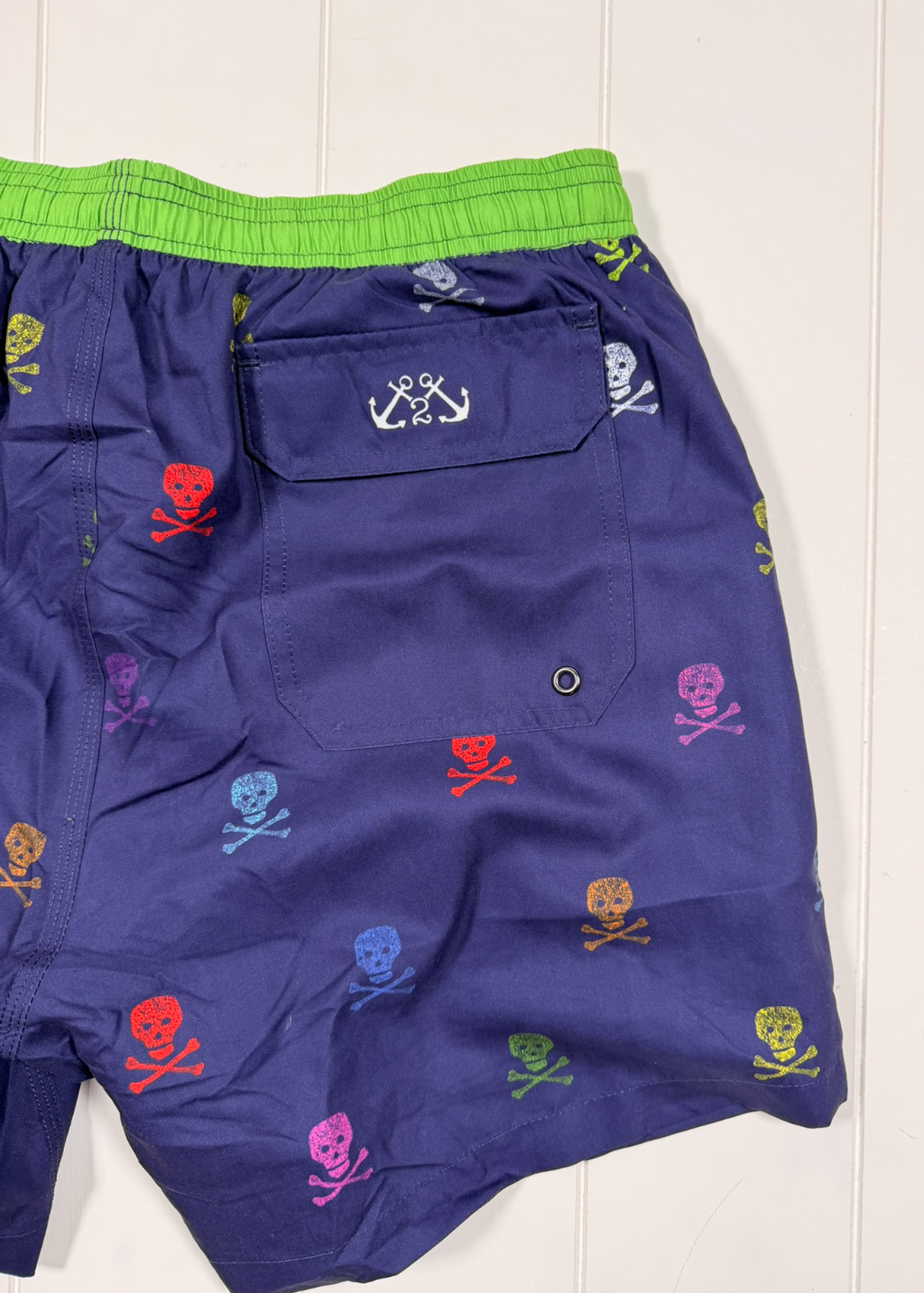 Blue shorts with colorful skull and crossbones pattern on a white background