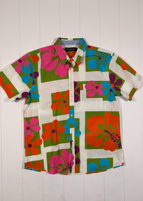 Colorful floral shirt with a brand label on a white wooden background