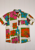 Colorful floral shirt with a brand label on a white wooden background