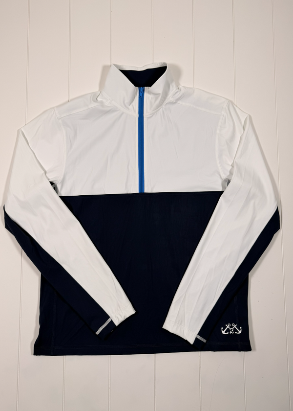 White and navy half-zip pullover with a brand logo on a wooden background