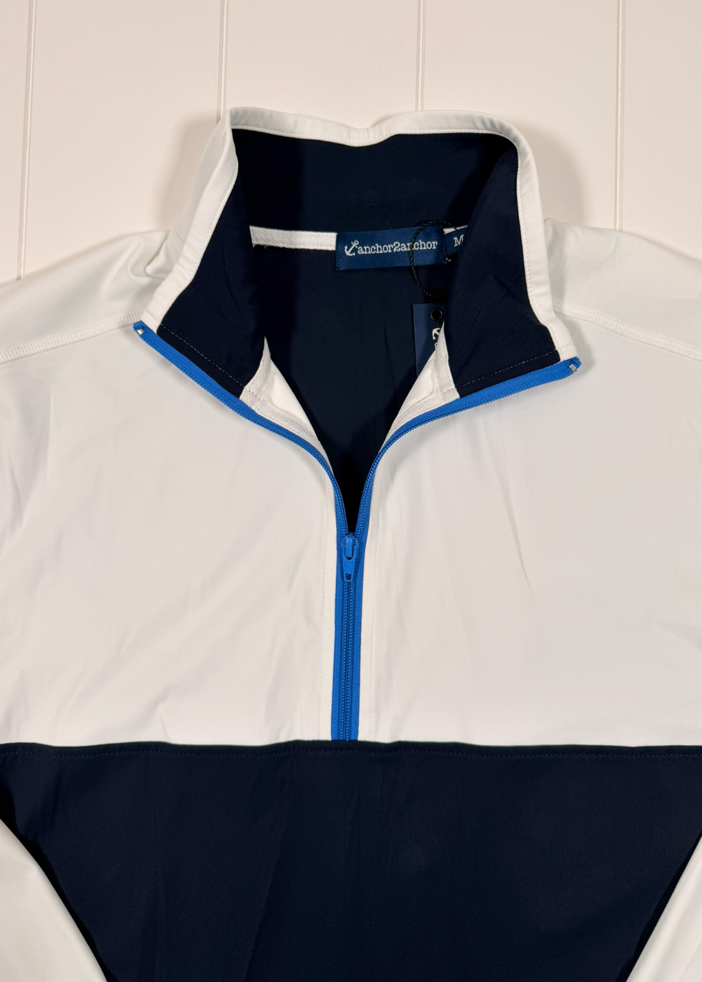 White and navy jacket with blue zipper on a white background
