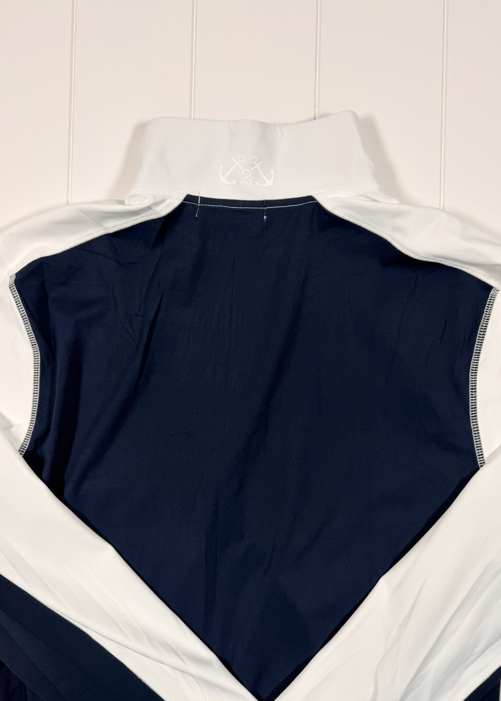 Navy sleeveless top with white trim on a light wooden surface