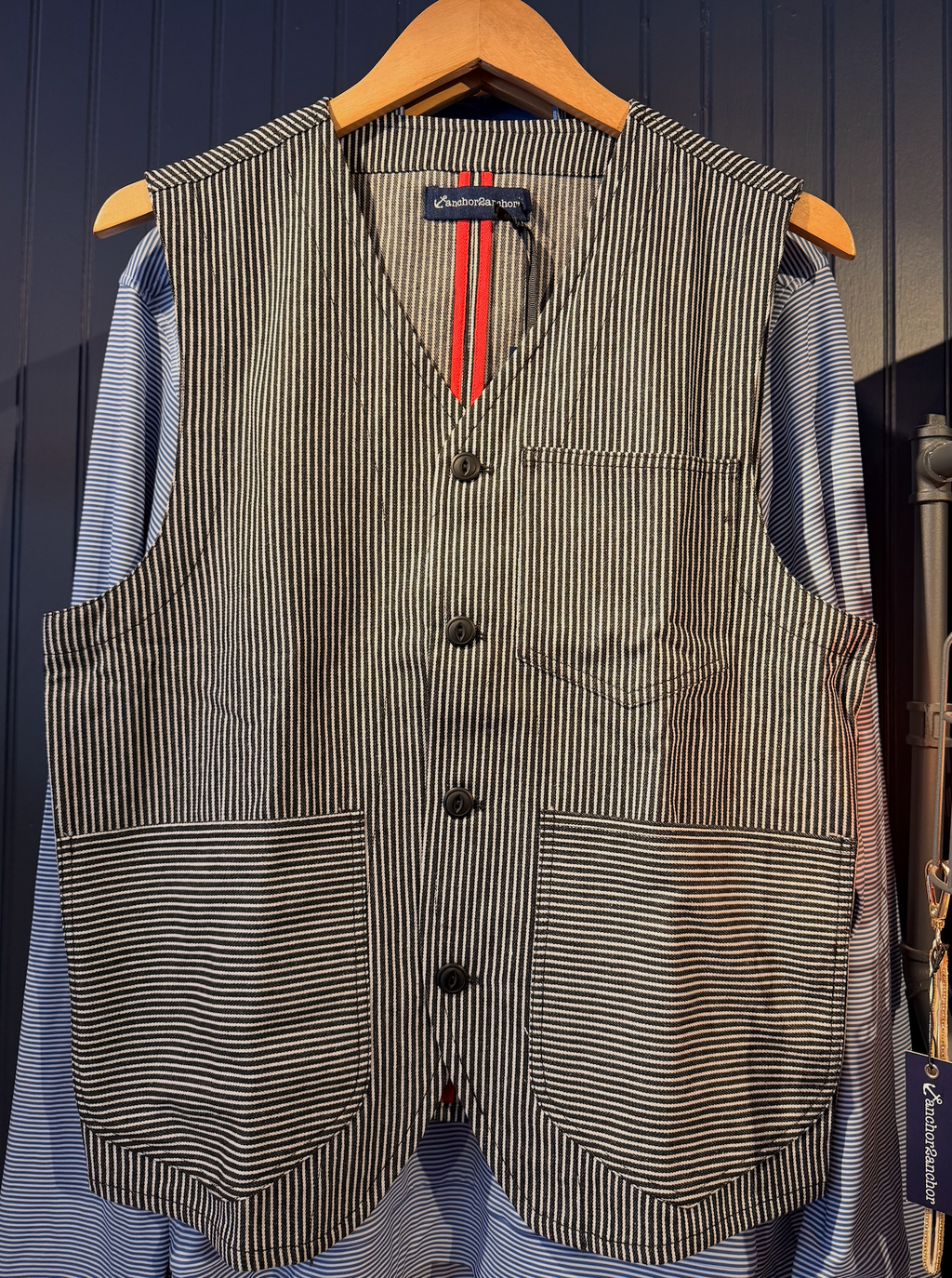 Striped vest on a hanger against a dark blue background
