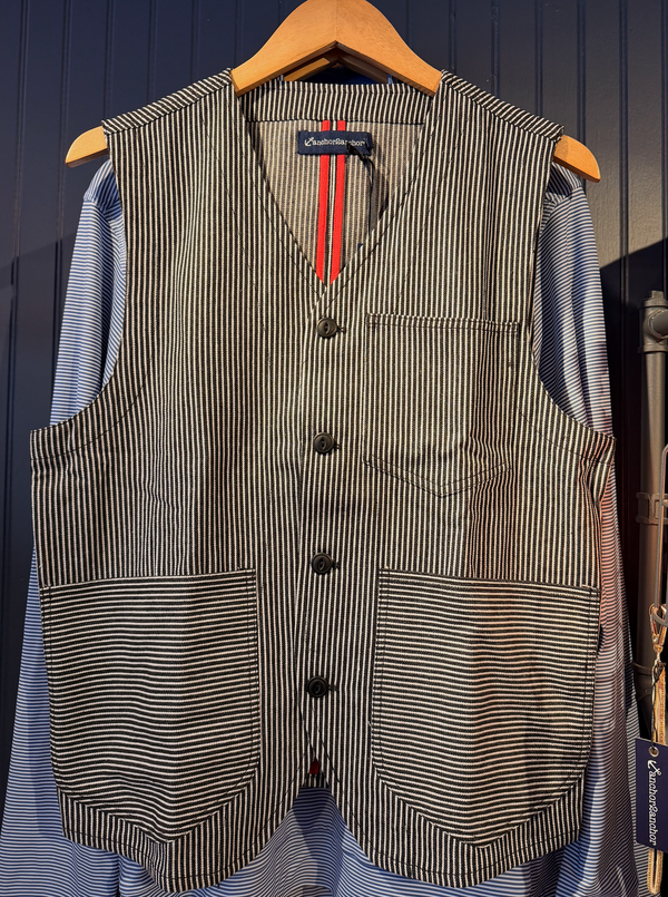 Striped vest on a hanger against a dark blue background
