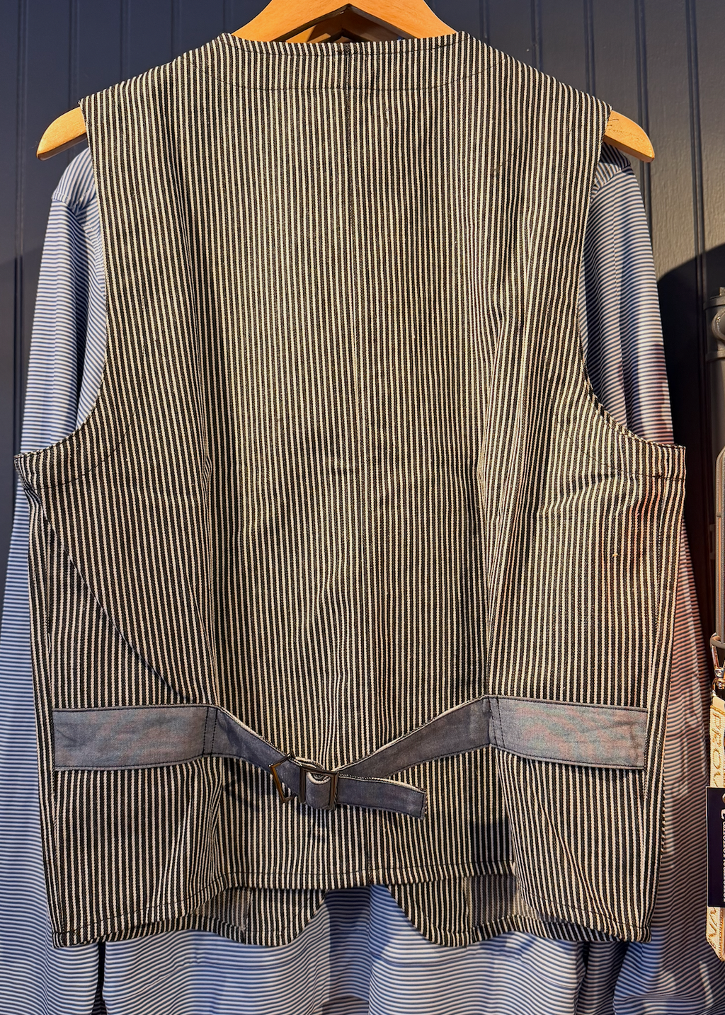 Striped vest on a hanger against a blue wall