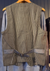 Striped vest on a hanger against a blue wall