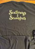 A dark charcoal gray t-shirt laid flat, featuring the words 'Scallywag's & Scoundrel's' printed in a light yellow gothic font across the chest.