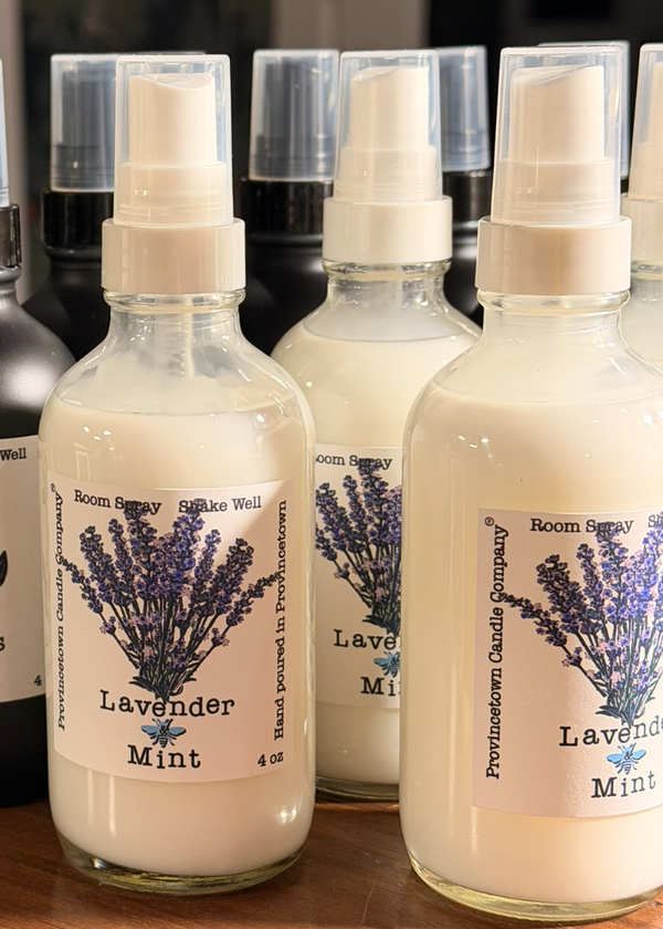 Three glass bottles of lavender mint room spray on a wooden surface with blurred background