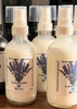 Three glass bottles of lavender mint room spray on a wooden surface with blurred background