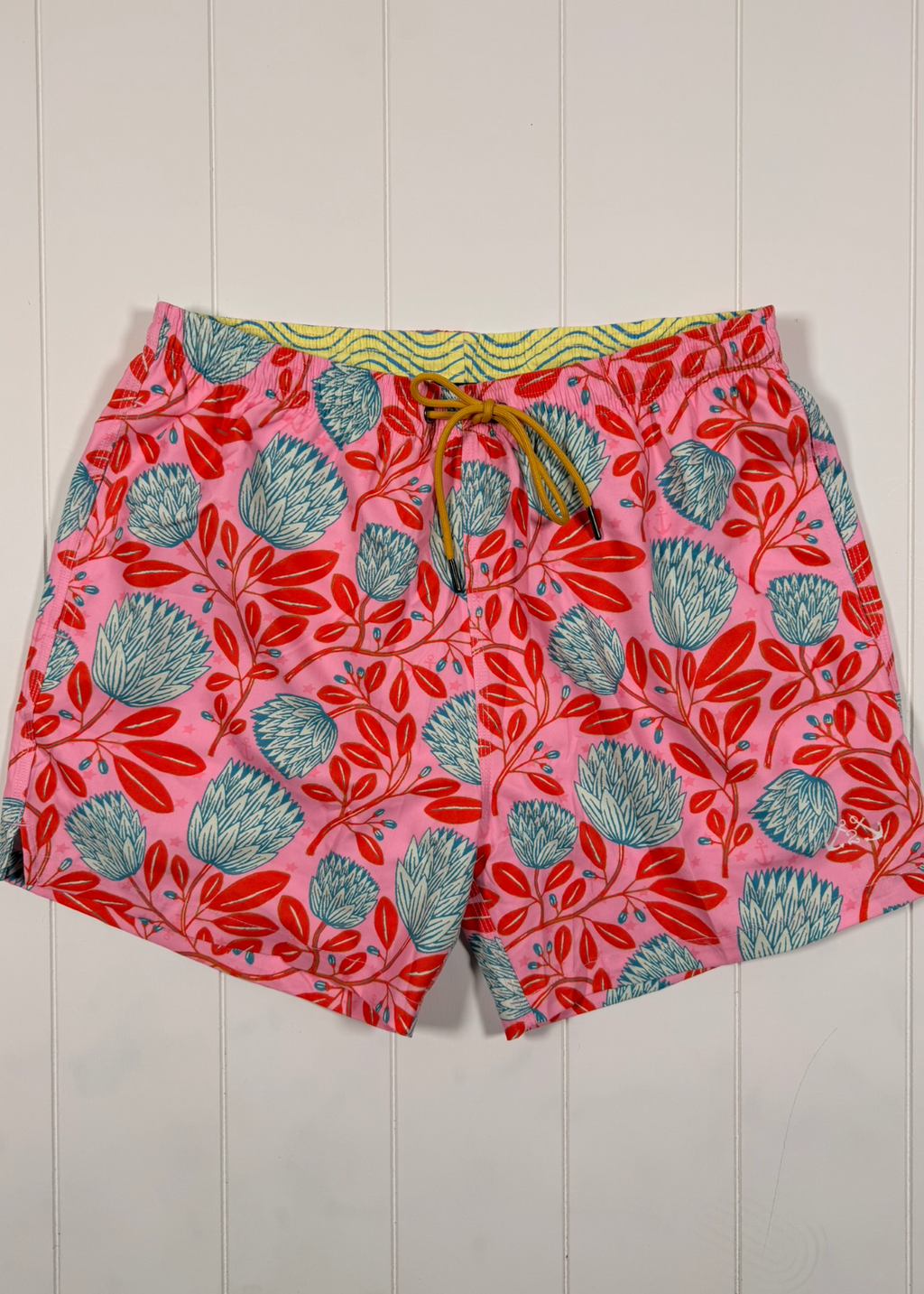 Floral patterned shorts on a white wooden background