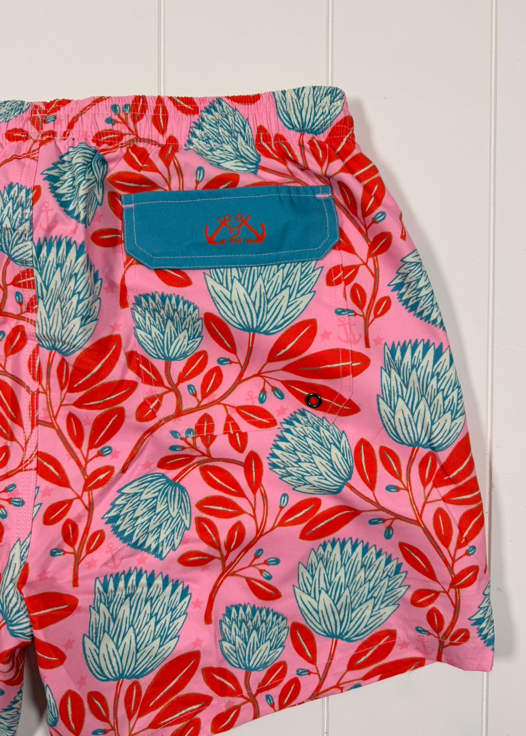 Pink shorts with blue and red floral pattern on a white background