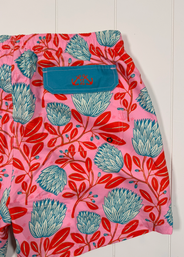 Pink shorts with blue and red floral pattern on a white background