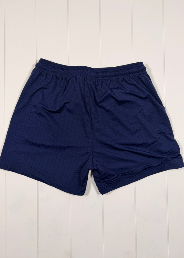 Navy blue shorts on a white wooden surface