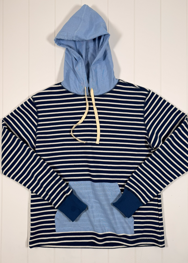 Navy and white striped hoodie with blue hood and cuffs on a light wooden background