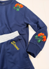 A navy blue sweatshirt with embroidered orange and green roses on the shoulders and sleeves, a light gray ribbed waistband, and yellow cursive embroidery reading 'Screws' on the pocket.