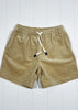 Beige shorts with a drawstring on a white wooden background