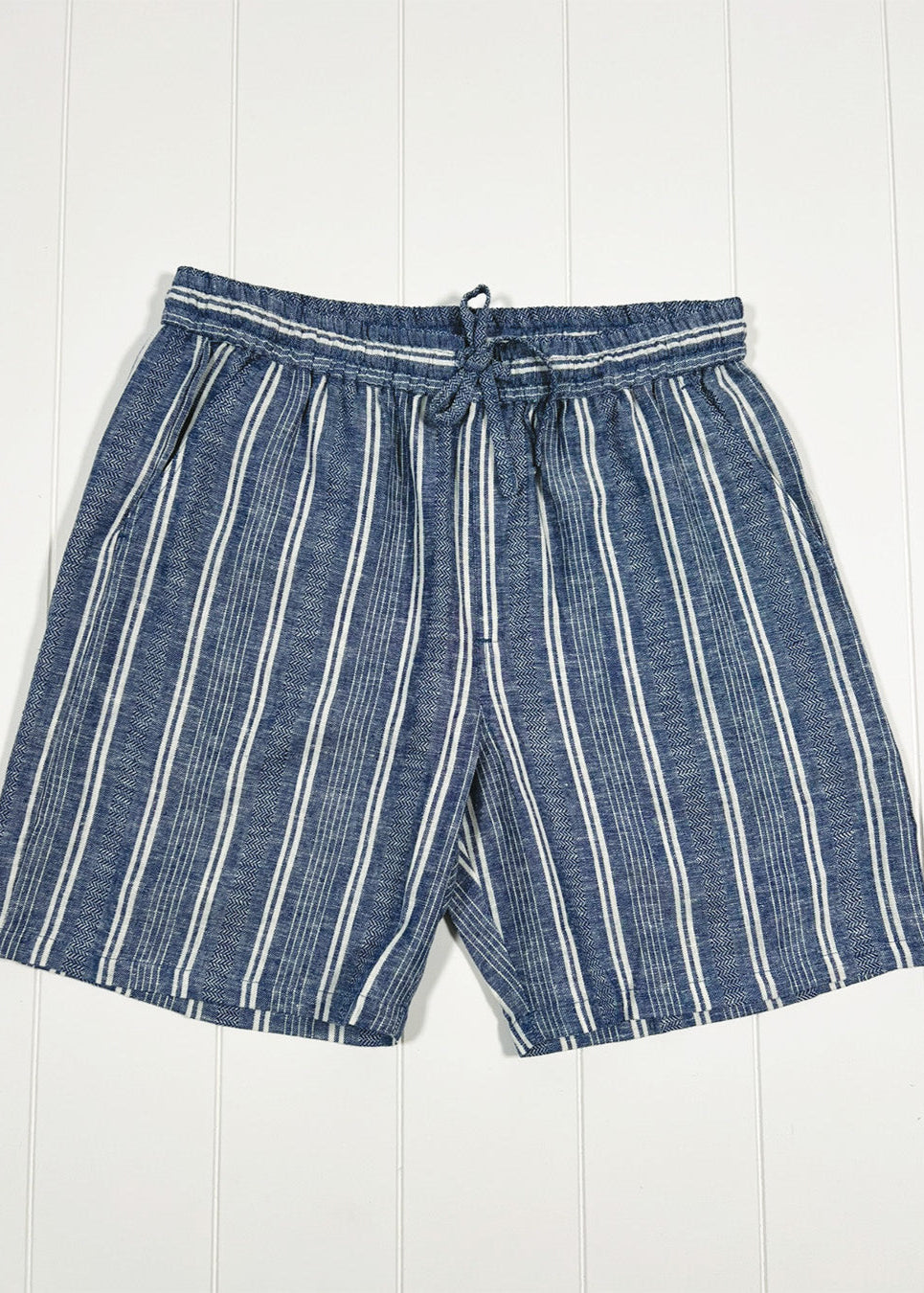 Blue and white striped shorts on a white wooden background
