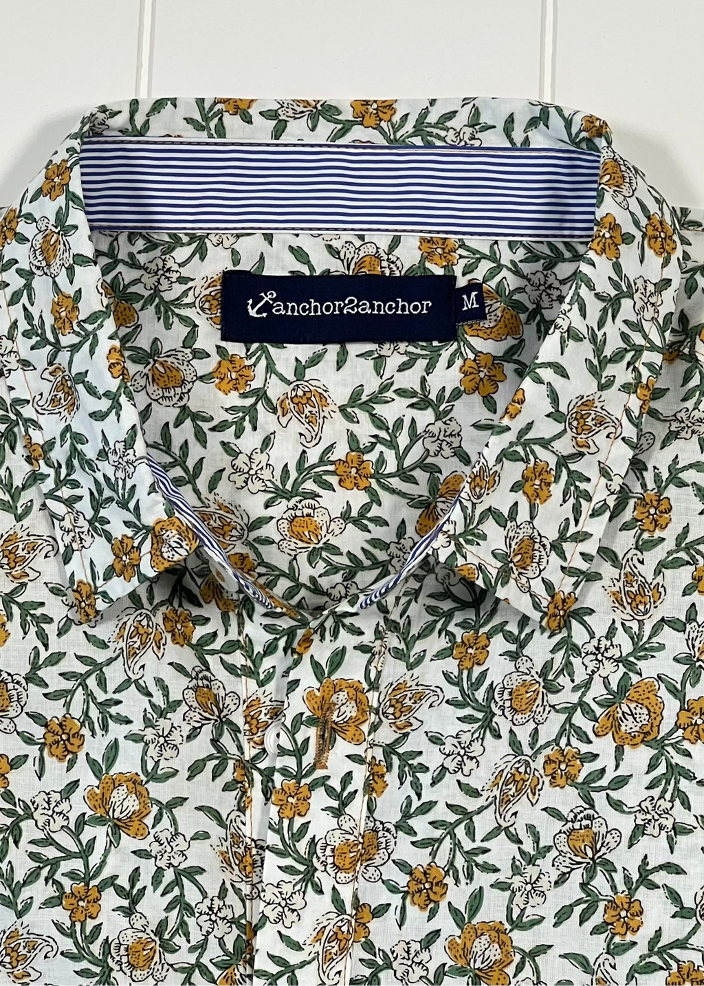 Floral patterned shirt with a brand label on a white background