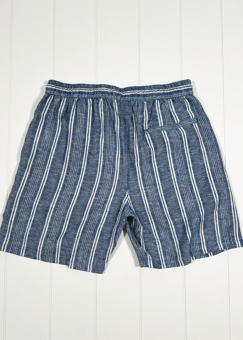 Blue striped shorts on a white wooden background
