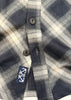 Close-up of a plaid shirt with a brand logo on a white background
