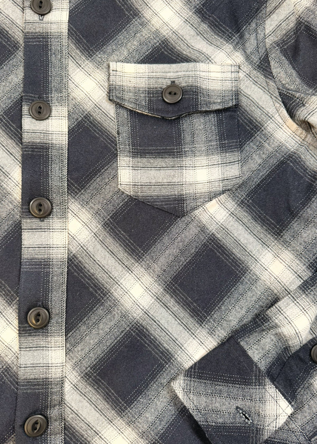 Close-up of a blue and white plaid shirt with button details