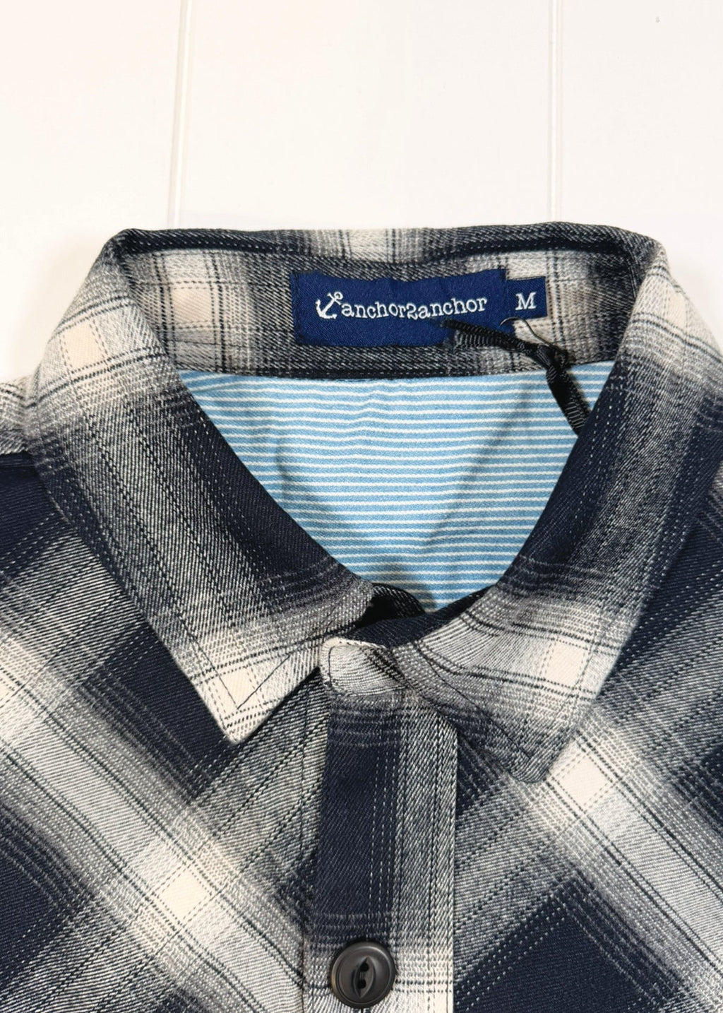 Plaid shirt with a visible brand label on a white background