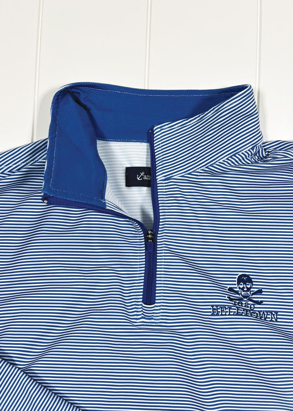Blue and white striped pullover with a skull and crossbones logo on a white background