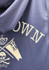 Close-up of a navy blue textured mesh fabric with cream-colored embroidered lettering and a skull-and-flag emblem.