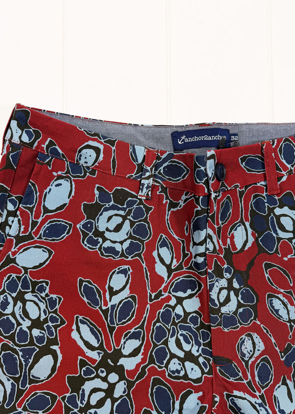 Red floral patterned fabric with a visible brand label on a white background