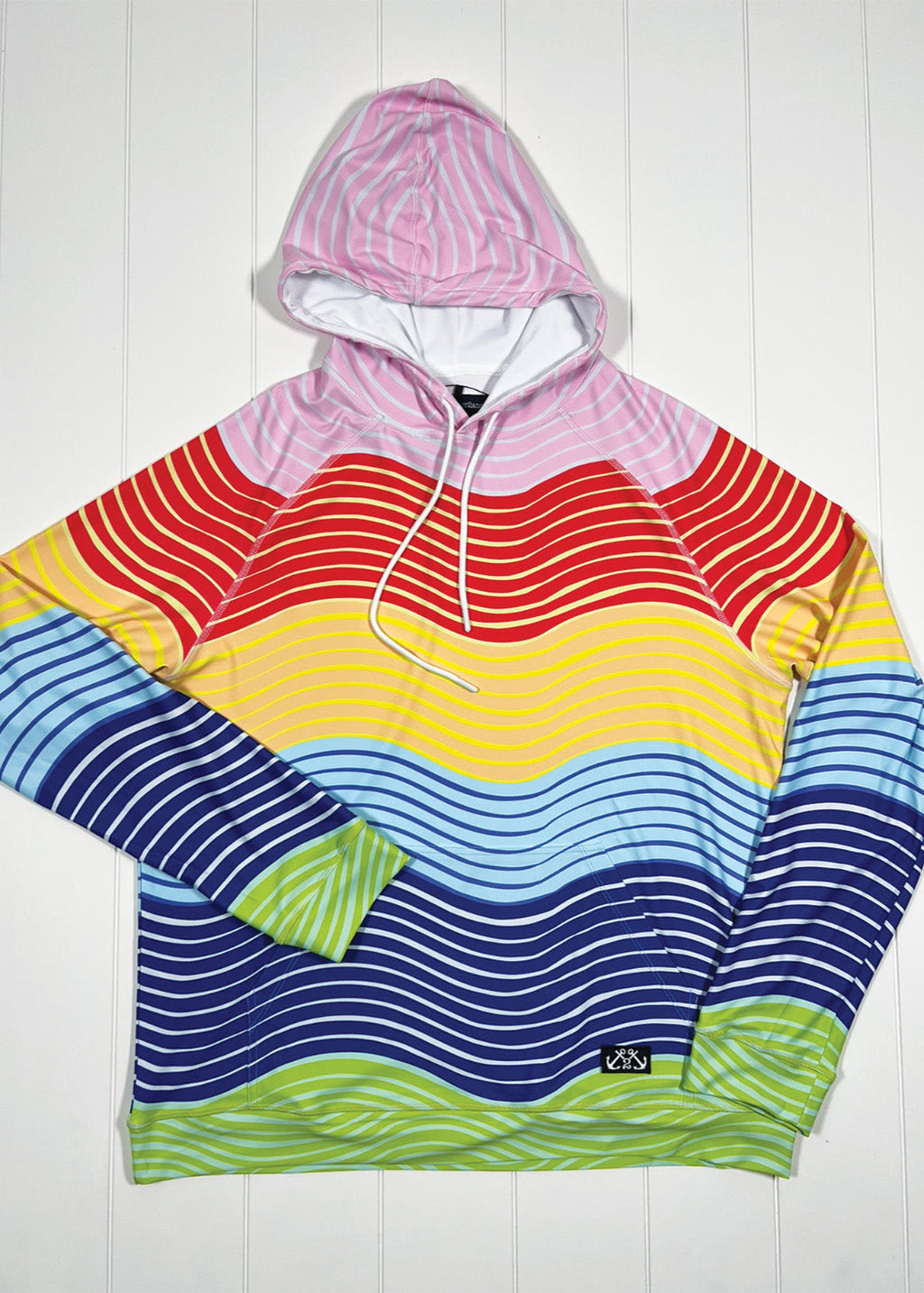 Colorful striped hoodie with a pink hood on a white wooden background