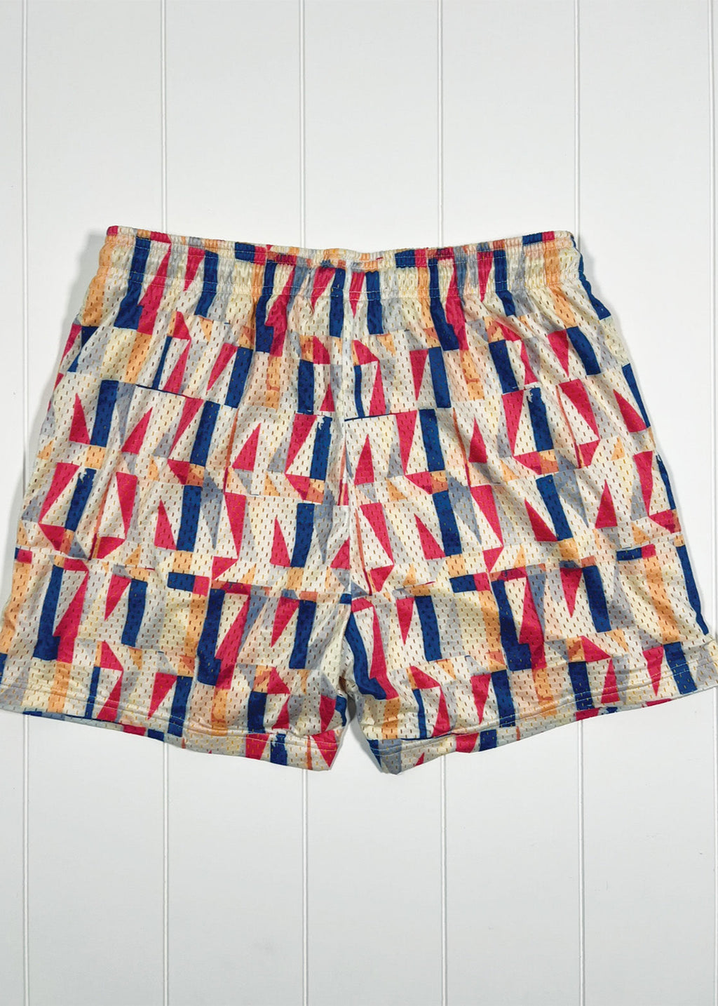 Colorful geometric patterned shorts on a white wooden background