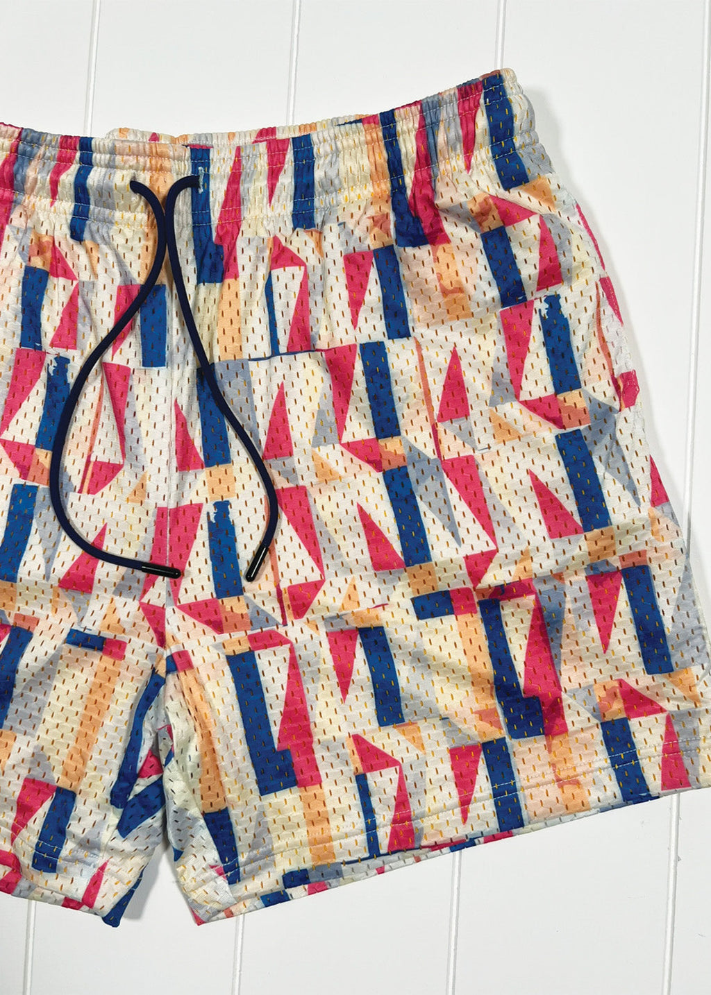 Colorful geometric patterned shorts on a white background