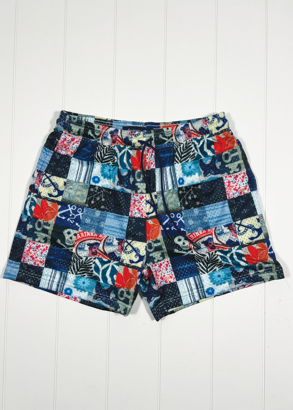 Patchwork shorts with nautical patterns on a white wooden background