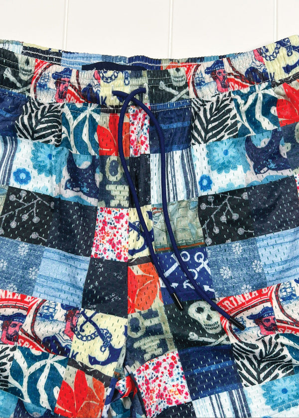 Multicolored patterned shorts with a mix of colors including blue, red, and black on a white background.