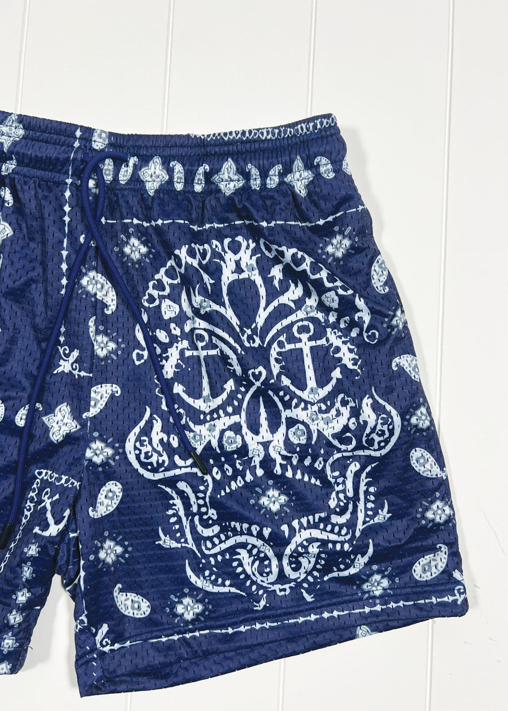 Navy blue shorts with white anchor and paisley pattern on a white background