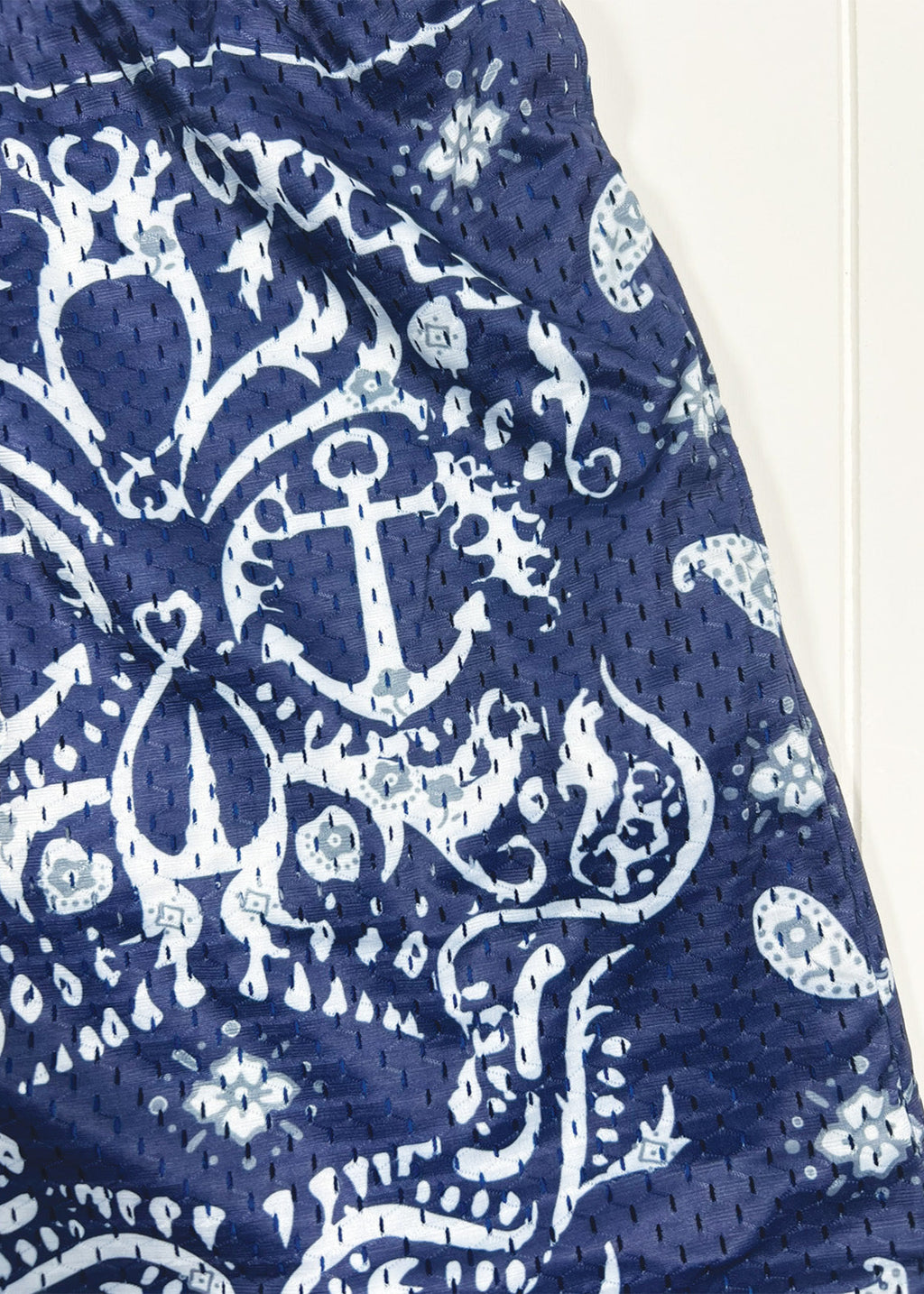 Navy blue fabric with white anchor and floral pattern on a white background
