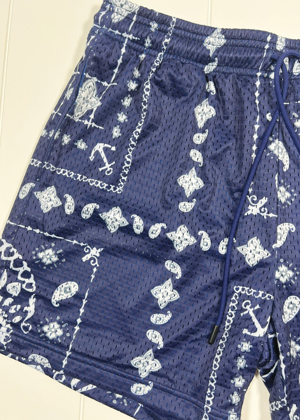 Blue shorts with white patterns on a plain background