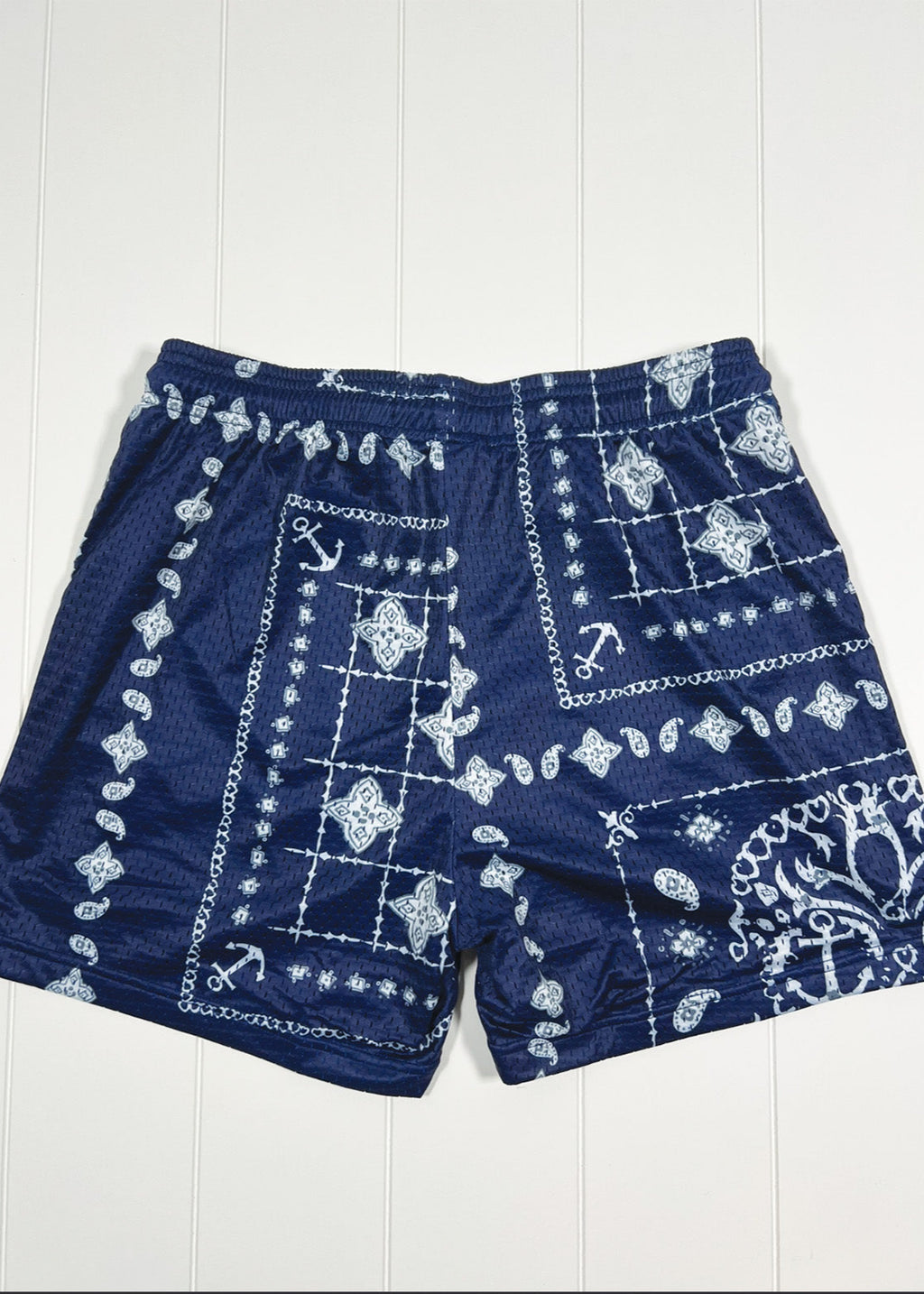 Navy blue shorts with white pattern on a white wooden background