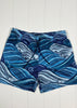 Blue wave-patterned shorts on a white wooden background