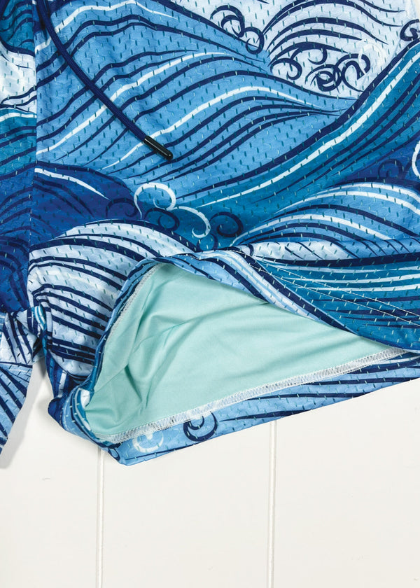Blue wave-patterned fabric with a light green lining on a white background