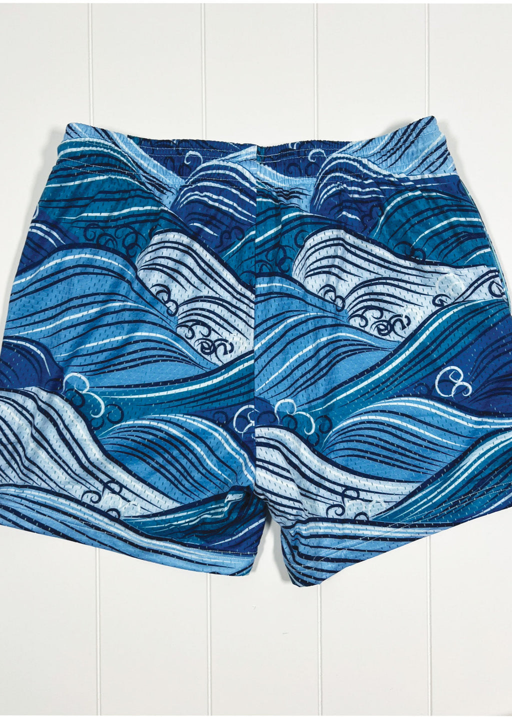 Blue wave-patterned shorts on a white background